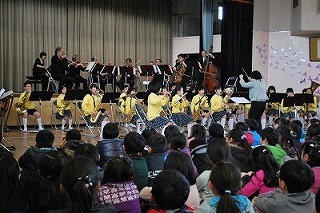 全校児童の前でプロと共演する吹奏楽部の児童
