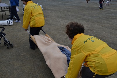物干しざおと毛布を使った簡易担架で被災者の救出・搬送を行う自治会員
