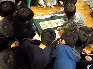 亀山さんのお手本の書き方を熱心に見つめる児童たち