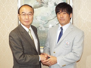 大久保博市長（左）とがっちり握手を交わし、五輪での活躍を誓う鈴木さん