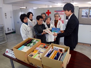 市川市福祉事務所の職員に寄贈する本を手渡す同奉仕団のメンバーたち