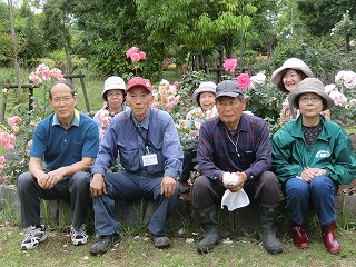 自ら手入れをしているバラを囲む武田代表（前列左から２人目）と両会のメンバーの一部
