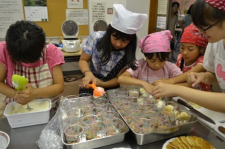 パティシエ気分でパンケーキ付きチョコとフルーツのパフェを作る子供たち