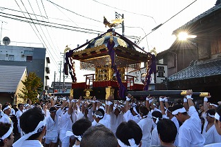 五カ町祭礼で白装束の男たちが神輿を天に向かって差し上げる