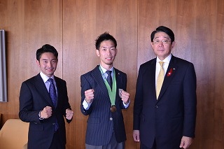メダルを胸に掲げファイティングポーズをとる林田選手（中）と兄でコーチの太郎さん（左）、松崎市長
