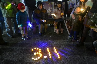 キャンドルで「3・11」を描いて犠牲者を追悼する参加者