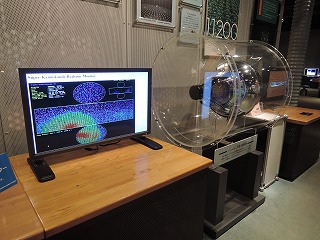スーパーカミオカンデの観測情報をリアルタイムで表示するイベントディスプレー（左）と光電子増倍管
